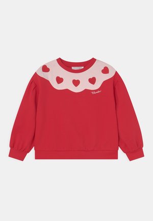 Rotes Sweatshirt mit langen Ärmeln und rosa gewelltem Einsatz, der fünf rote Herzen und das kleine, kursiv geschriebene "Charabia"-Logo auf der Brust zeigt.