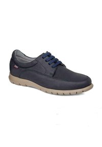 Zapatos de cuero azul marino con puntera redonda, cordones azules y suela de goma beige que cuenta con un patrón texturizado para mejorar la tracción.