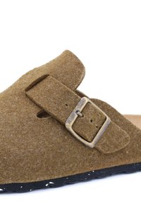 Sandale en feutre marron avec une large bride et une boucle métallique. Elle présente une forme arrondie et une surface texturée. Semelle extérieure noire avec des éclaboussures blanches.