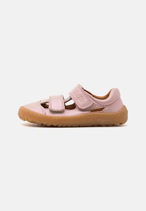 Chaussure enfant rose avec deux bandes velcro et une semelle en caoutchouc marron, vue de profil sur fond blanc.