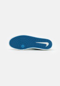 Blue sneaker sole with a textured zigzag pattern and a white Nike swoosh. The rubber sole features a rounded toe and a curved heel area.