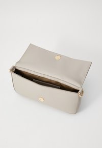 Borsa a mano in pelle crema con design pieghevole, accessori in oro e tasca interna per carte. Texture liscia, forma rettangolare e chiusura magnetica.