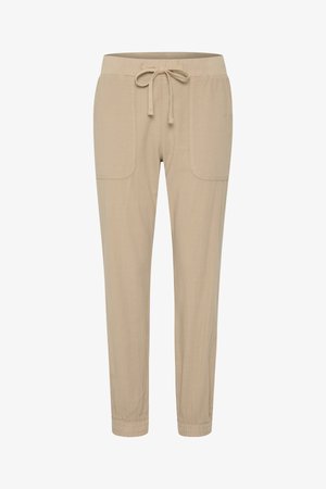 Pantalons beige à cordon de serrage avec une coupe décontractée, dotés de deux poches avant, de poignets élastiques et d'une texture douce.
