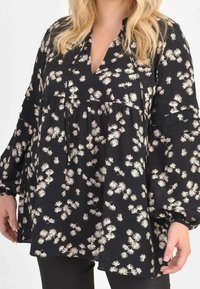 Blusa nera floreale con scollatura a V, maniche lunghe a campana e design a strati con piccoli motivi di fiori bianchi e rosa, realizzata in tessuto leggero.