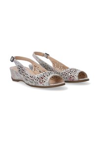 Slingback-Sandalen mit offener Zehe, mit lasergecuttetem Blumenmuster, in hellbeige Farbe und mit niedrigem Keilabsatz. Verstellbarer Knöchelriemen.
