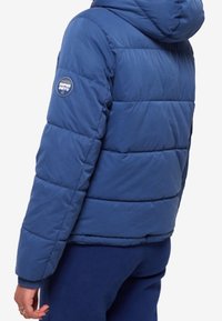 Blauwe pufferjack met een capuchon, voorzien van horizontaal geregen delen, een logo-opdruk op de linker mouw en een gladde, matte textuur.