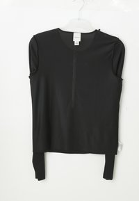 Zwarte mouwloze mesh top met een ronde halslijn, zichtbare Calvin Klein-label, hanging aan een transparante plastic hanger tegen een witte achtergrond.