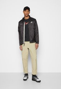 Nike Sportswear Corta-vento - anthracite/light bone