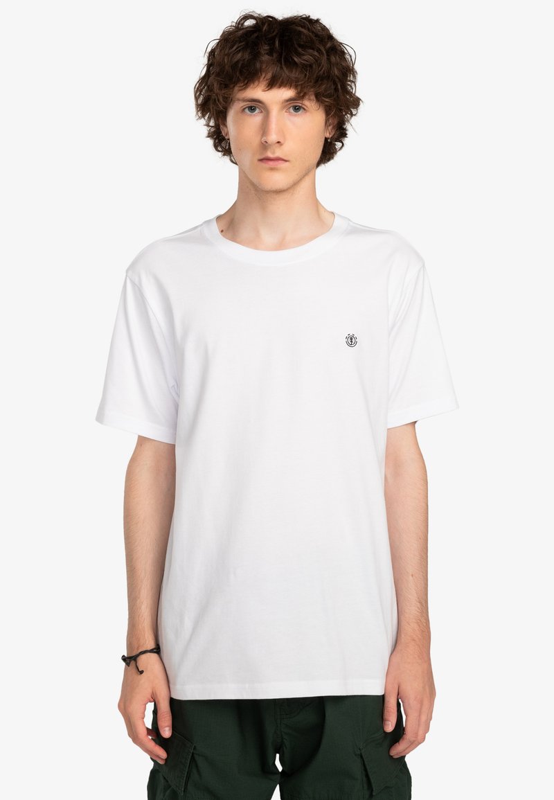 Hvid bomulds T-shirt med rund halsudskæring, korte ærmer og et lille sort emblem på brystet. Glat tekstur, afslappet pasform.