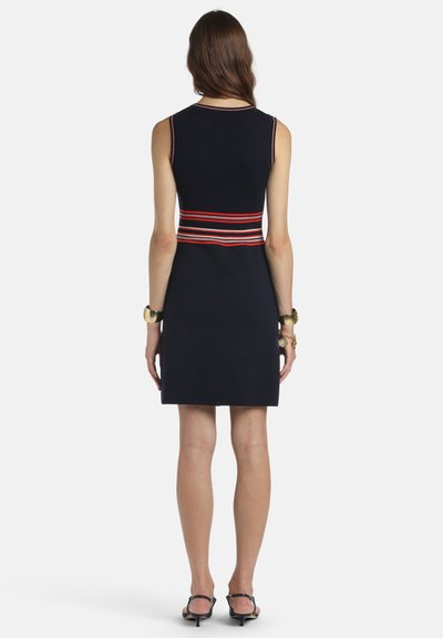 Tmavomodré šaty bez rukávov s priliehavým strihom a pásom s červenými, bielymi a modrými pruhmi. Hladká látka a dĺžka po kolená.