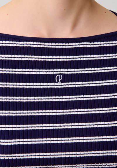 Top a coste blu navy con righe orizzontali bianche, con un logo ricamato al centro. Lo scollo è ampio e scivolato sulle spalle.