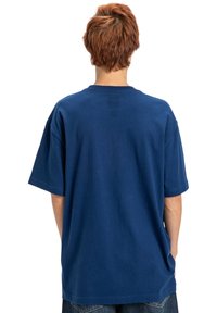 Námornícky modré voľné bavlnené tričko s krátkymi rukávmi a okrúhlym výstrihom, s jednoduchým dizajnom a voľným strihom.