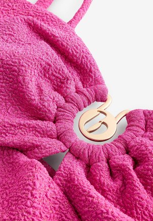 Roze textiel met een glanzende afwerking, voorzien van een geplooid ontwerp en een connector van metaal in goudkleur in het midden.