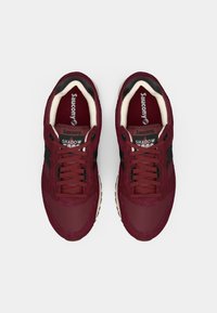 Burgunderfargede sneakers med overdel i mesh og semsket skinn, svarte detaljer og runde skolisser. Har en polstret innside og gummisåle.