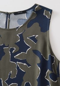Sleeveless top in dark green and navy with abstract white pattern, featuring a rounded neckline and a back zipper closure. Fabric appears smooth.