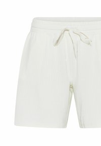 White ribbed shorts with an elastic waist, featuring a drawstring. The fabric has a soft texture and a straight cut with no visible pattern.