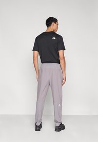 Μαύρο κοντομάνικο T-shirt και γκρι ελαφρύ παντελόνι με ελαστική μέση, με λογότυπο στην πλάτη και στα πόδια.