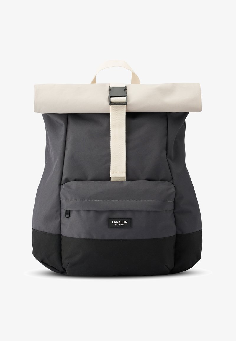 Szürke hátizsák krém színű felhajtható tetővel és fekete alappal. Elöl zsebe van, ezüst színű fémrészekkel és textilpánttal a záródásért.