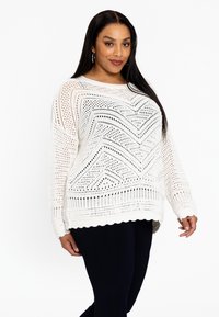 Weißer, gestrickter Pullover mit Zickzackmuster, langen Ärmeln und gewelltem Saum. Besitzt eine offene Maschenstruktur und eine lässige Passform.