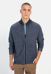 Marineblauer Strick-Cardigan mit Reißverschluss, einem strukturierten Muster, gerippten Bündchen und Saum sowie einem kontrastierenden goldenen Reißverschlusszug.}}