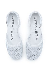 Weiße Ballettschuhe mit einer glatten, glänzenden Oberfläche, die mit silbernen Strasssteinen bedeckt sind, ausgestattet mit einem verstellbaren Knöchelriemen und einer gepolsterten Innensohle.