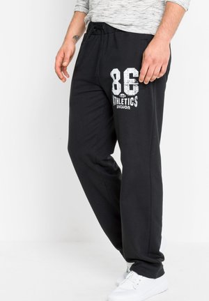 Schwarze Sporthosen aus weichem Stoff, mit einem Kordelzugbund, Seitentaschen und einem weißen Drucklogo mit "86" und "Athletics Division."