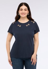 Námořnická modrá bavlněná tričko s krátkým rukávem, zdobené výřezem na výstřihu ve tvaru listů. Hladký materiál, volný střih.