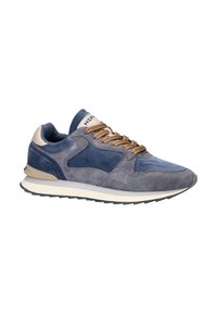 Suède en stof sneaker in donkergrijs en blauw, met beige accenten, textuurveters en een witte zool met een zwart profiel.