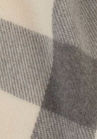 Tessuto in morbida lana con un ampio motivo a quadri nei colori beige, grigio chiaro e grigio scuro, che mostra una dettagliata texture in lana.