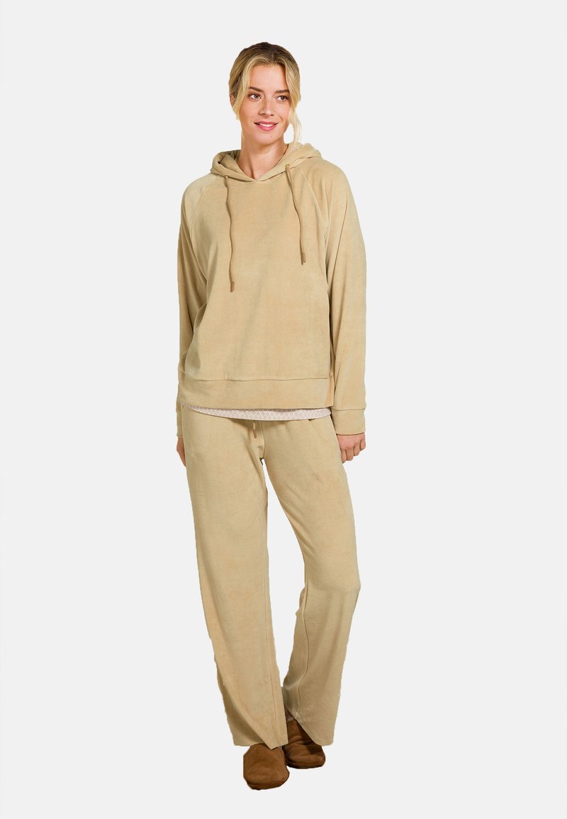 Beige hoodie met een ontspannen pasvorm en trekkoorden, gecombineerd met bijpassende brede joggingbroek in een zachte, gestructureerde stof.
