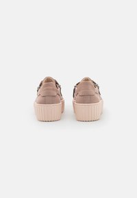 Lichtroze suède sneakers met een geribbelde rubberen zool, geschulpte accenten aan de achterkant en zilveren hardware voor verstelbare banden.