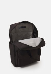 Sac noir de forme rectangulaire, fabriqué à partir de matériaux recyclés. Il dispose d'une fermeture éclair, d'un intérieur gris et d'un compartiment transparent.