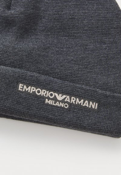 Hallitud hall müts, mis on varustatud volditud äärisega, esiküljel on valge tikitud "Emporio Armani Milano" logo. Pehme tekstuur.