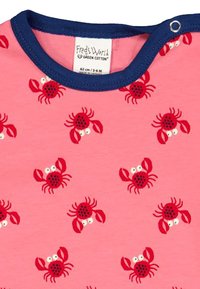 Chemise en coton rose à manches courtes et col rond marine, présentant un motif répété de crabes rouges avec des taches noires et des yeux blancs.