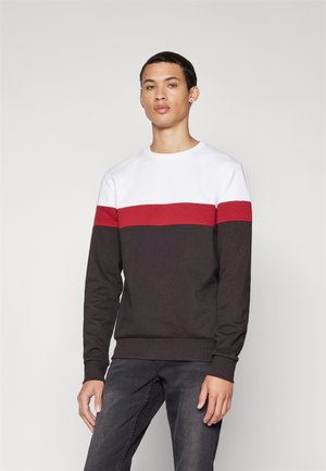 Herresweater i svart, hvit og rød. Har rund hals og lange ermer med fargeblokkdesign. Mykt, bomullsmateriale med ribbestrikkede mansjetter.