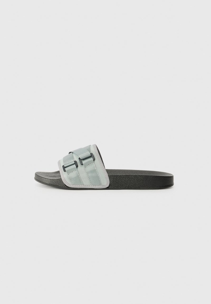 Chinelo com faixa verde menta, apresentando duas fivelas pretas, sola contornada preta e bordas cinza texturizadas.