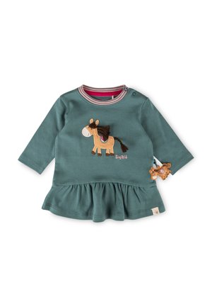 Langärmliges, türkisfarbenes Baumwinkleid mit gerafftem Saum, das eine braune Pferdeapplikation und ein kleines Pferdetäfelchen an der Seite aufweist.