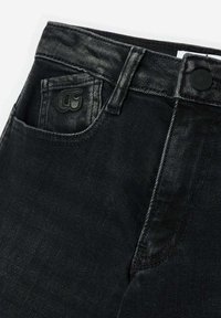 Jean en denim noir avec une texture délavée, comportant une poche avant et un patch de marque. Comprend une fermeture à bouton et des coutures robustes.