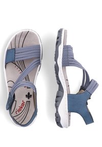 Blaue Sandalen aus einer Mischung von Textil und synthetischem Material. Sie verfügen über überkreuzte Riemen, eine gepolsterte Innensohle und eine strukturierte Gummisohle.