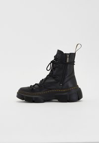 Black leather ankle boot with a chunky sole, lace-up front, side zipper, and yellow stitching accents. Textured finish and sturdy design.