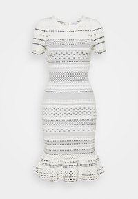 Robe blanche ajustée ornée de motifs texturés en noir et crème, avec des manches courtes et un ourlet évasé en bas.