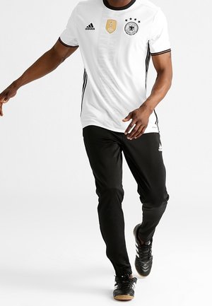 White Adidas jersey featuring black accents, FIFA logo, and German national emblem. Paired with black pants and black soccer shoes.