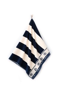 Granatowo-kremowy pasiasty koc o miękkiej teksturze, z dekoracyjnymi wzorami morskimi wzdłuż krawędzi i zawieszką do eksponowania.