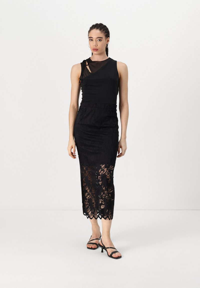 Musthave mustripu top, mille kattega, musta pitsist maxi seelik, millel on laineline äär ja lillemuster.