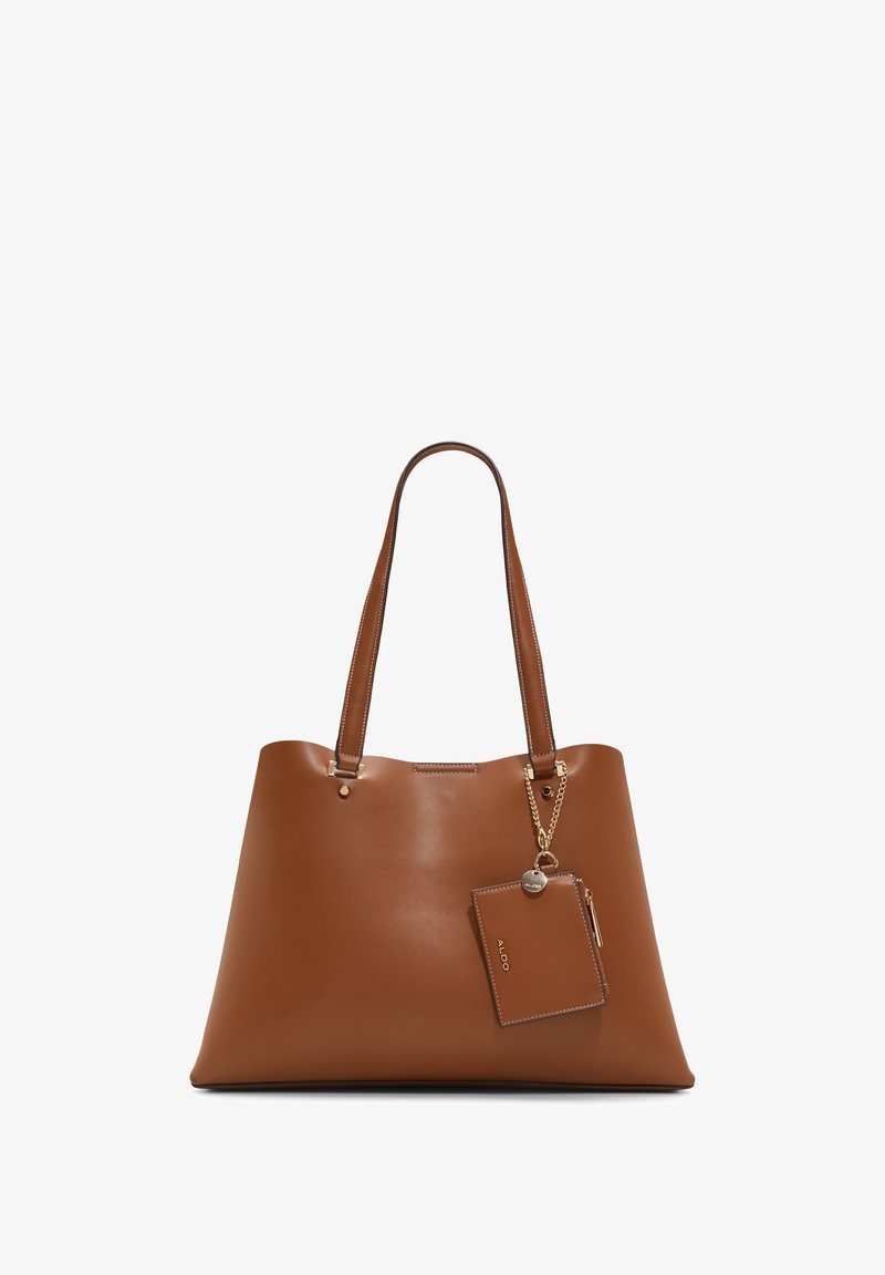 Sac fourre-tout en cuir marron avec un corps plat et large, des doubles bretelles et une étiquette amovible. Texture lisse avec des détails de couture subtils.