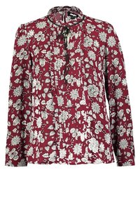 Blouse bordeaux manches longues avec motif floral blanc, devant froncé et nœud noir au col.