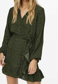 Robe fleurie verte à manches longues, col en V, design portefeuille et accents à volants le long de l'ourlet. Confectionnée en tissu léger et transparent.