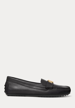 Zwarte leren loafer met gouden metaal detail op het bovenwerk en rubberen nopjes op de zool en hak voor grip.