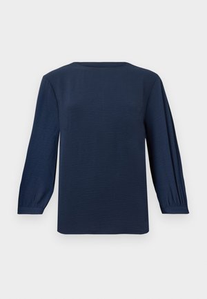 Blouse bleu marine à manches longues avec un col rond, des détails plissés sur les manches, des poignets ajustés et un tissu texturé.