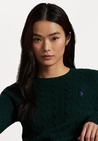 Groene kabelgebreide trui van textuurstof, met een ronde halslijn en een klein paars polo-logo accent op de linkerborst.